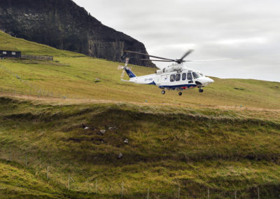 Helikopter lander på Mykines på kør-selv ferie, bilferie og grupperejser med FÆRØERNEREJSER